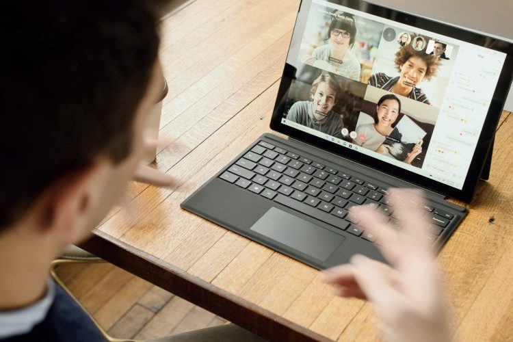 Person gesturing at Surface computer on a video virtual call